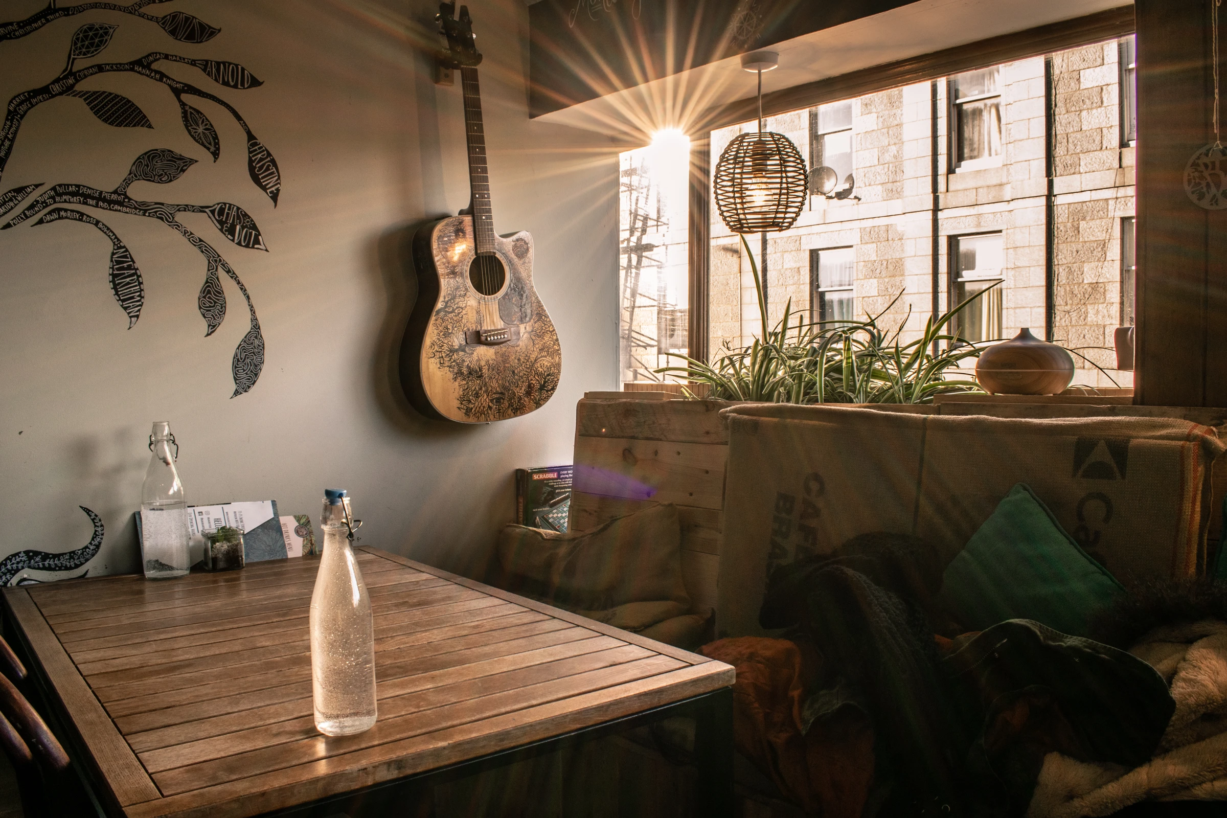 Sunlight entering a café seating area with a guitar on the wall